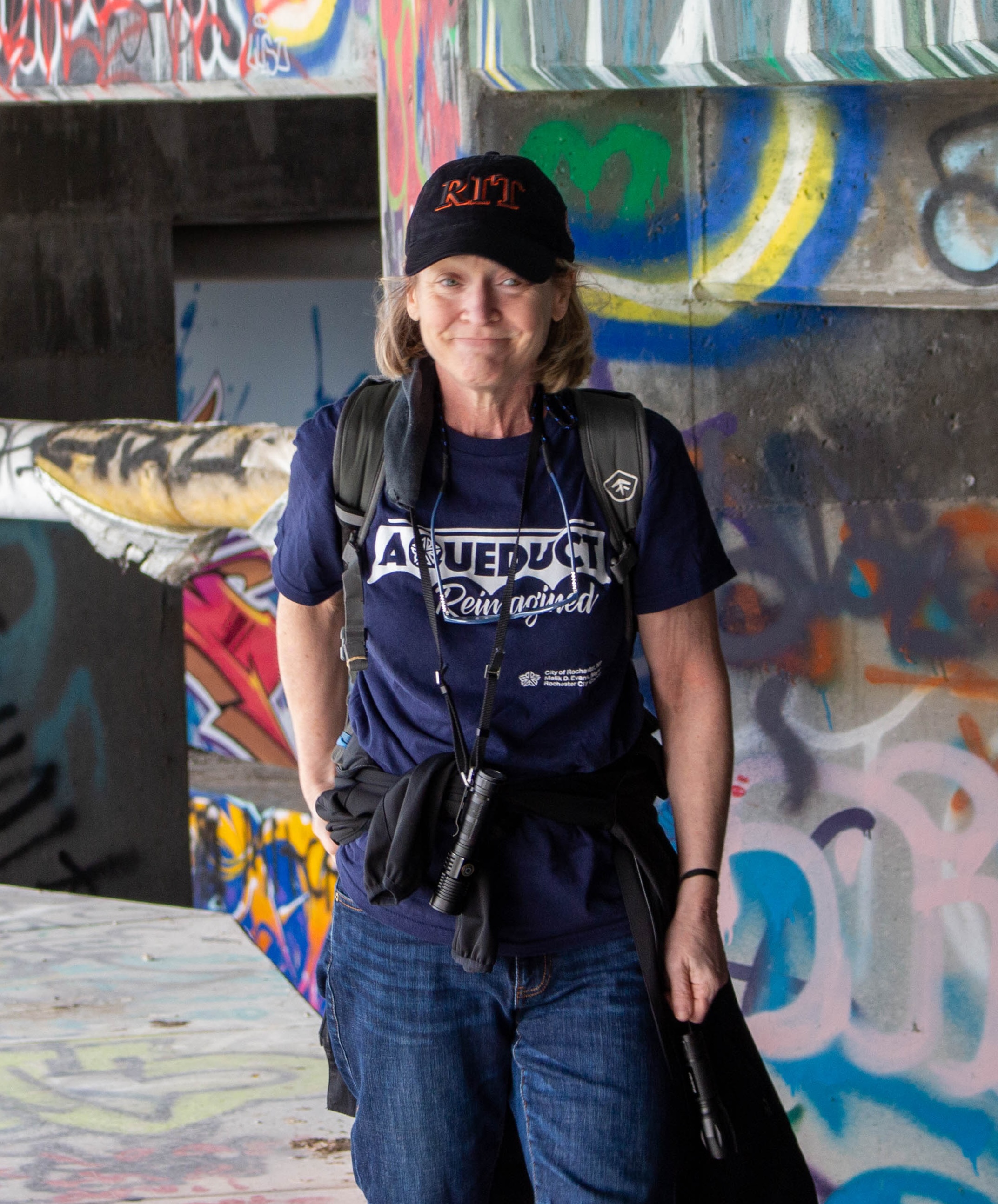 Jessical Lieberman walking on a part of the subway aqueduct covered in graffiti